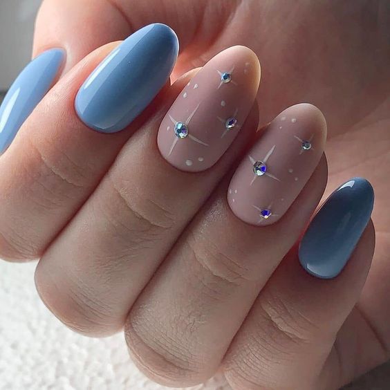 Design de unhas azuis amendoadas com strass lindos em duas unhas