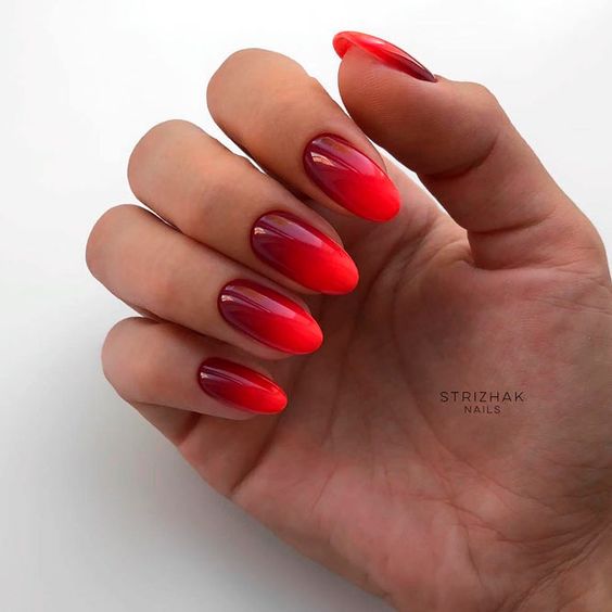 Exemplo de unhas amendoadas em tons de vermelho