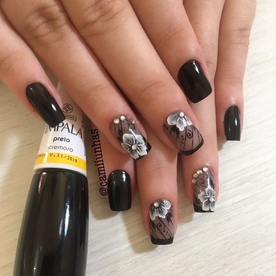 foto de unhas pretas com desenhos de flores brancas