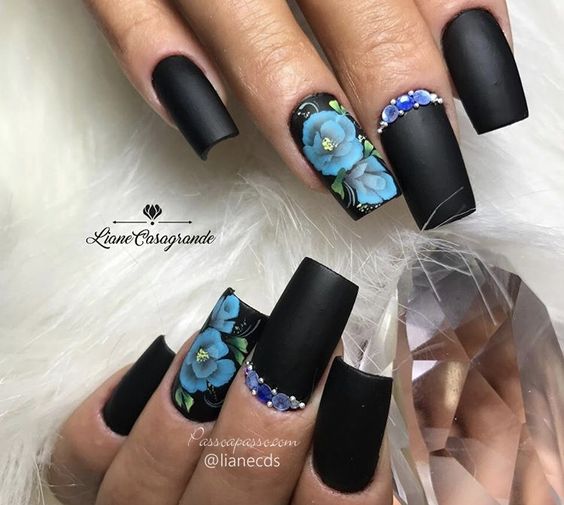 modelo de unhas pretas com floral azul