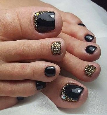 unhas dos pés decoradas na cor preta com pedras douradas