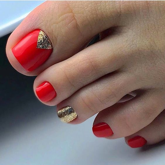 unhas dos pés vermelhas com decoração dourada