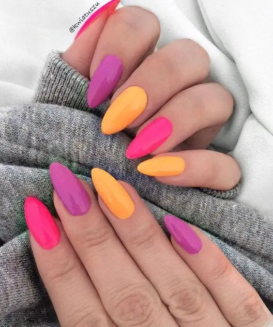 mãos com unhas decoradas utilizando três cores combinando
