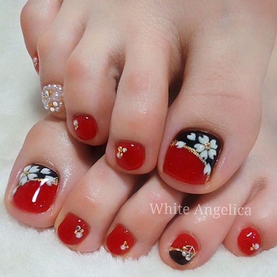 unhas dos pés pintadas de vermelho e detalhadas em preto