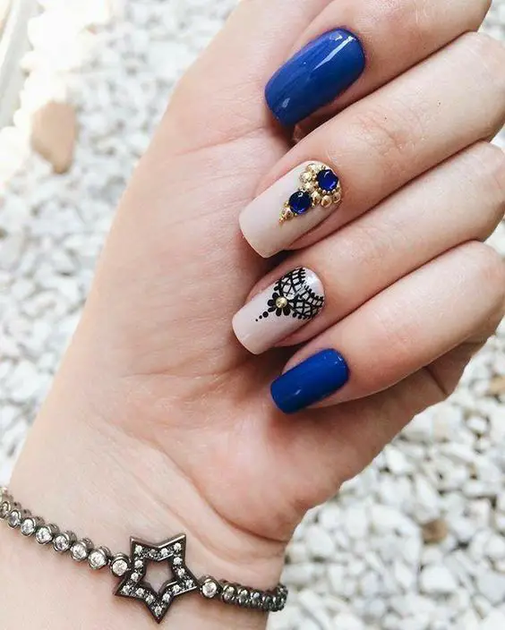 unhas azuis com flores e pedras bonitas