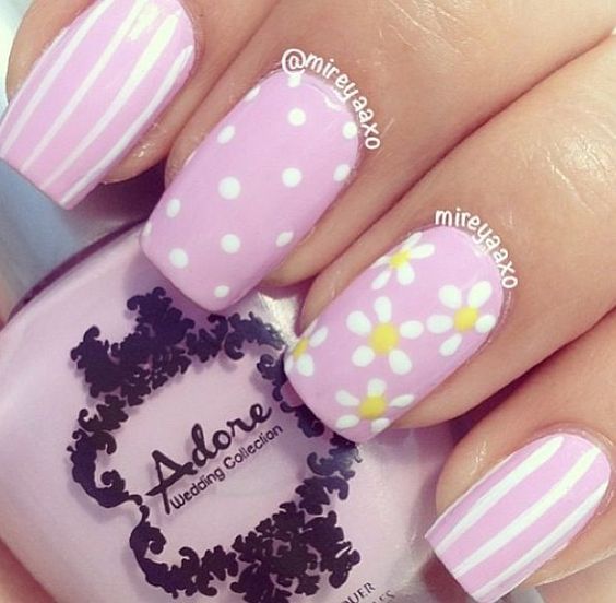 decoração em unhas de gel na cor rosa com pontos brancos e flores