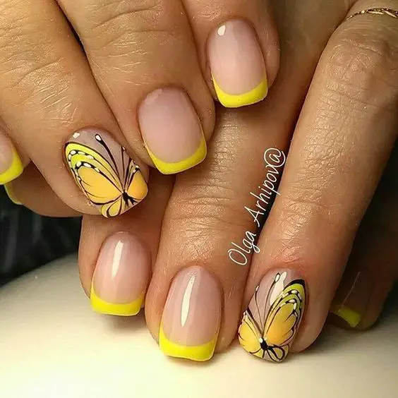 unhas em gel com francesinha amarela e com decorações de borboletas