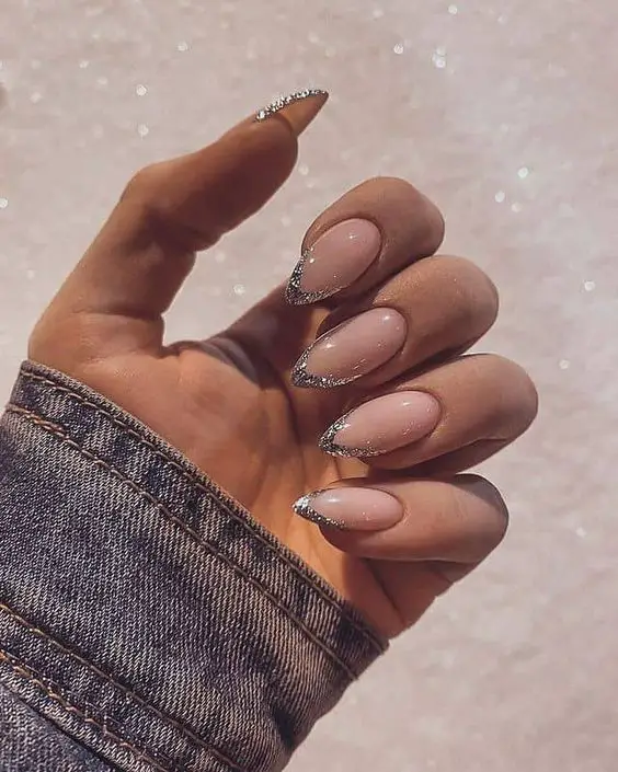 unhas nude amendoadas com detalhes prateados nas pontas