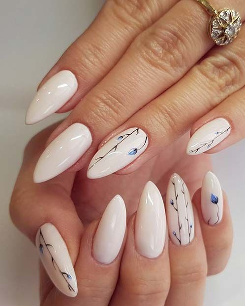 unhas amendoadas decoradas com padrões florais azuis