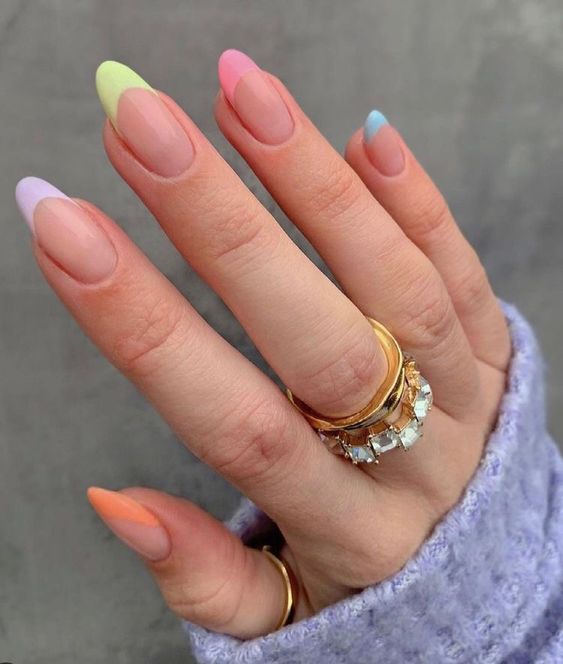 mão com unhas pintadas de francesinha com diferentes cores