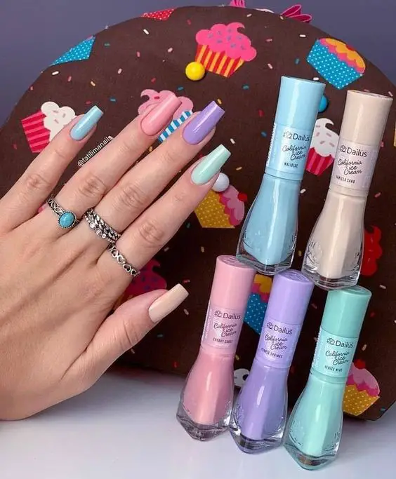 unhas pintadas com diferentes esmaltes em tons pastéis