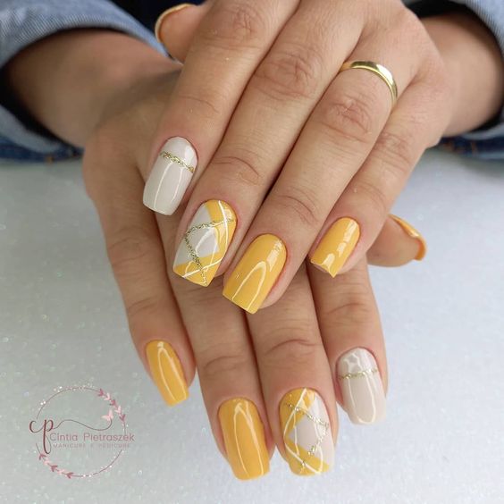 unhas com esmalte amarelo brilhantes de cada signo