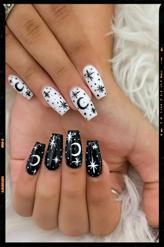 Unhas brancas e pretas com desenhos de lua e estrela