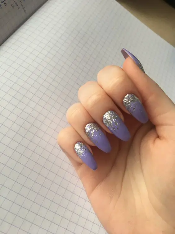 modelo de unhas roxas decoradas com brilhos prateados