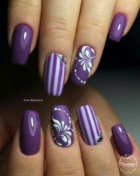 unhas roxas com desenhos florais e listras brancas