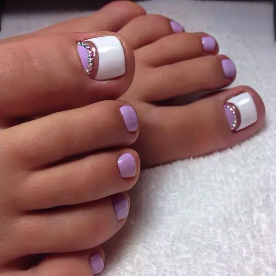 unhas do pé pintadas com esmaltes roxo e branco