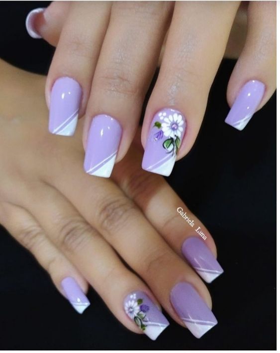 modelo de unhas delicadas roxas com desenhos de flores brancas