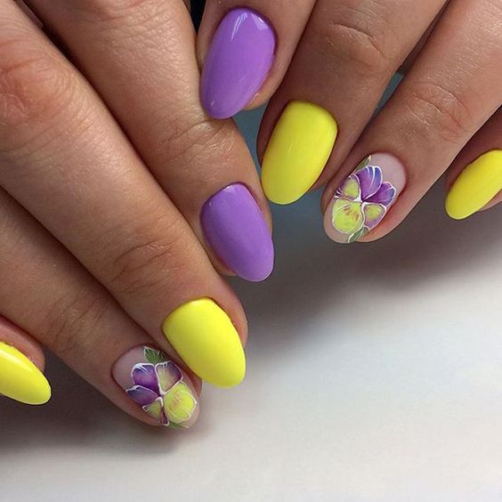 unhas com esmaltação nas cores de amarelo e roxo