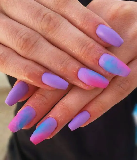 tendência de unhas tie dye roxas com rosa e azul