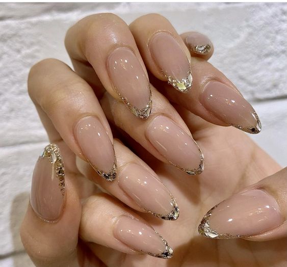 unhas amendoadas com nude e glitter dourado nas pontas