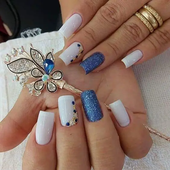 Decoração de unhas branca com glitter azul