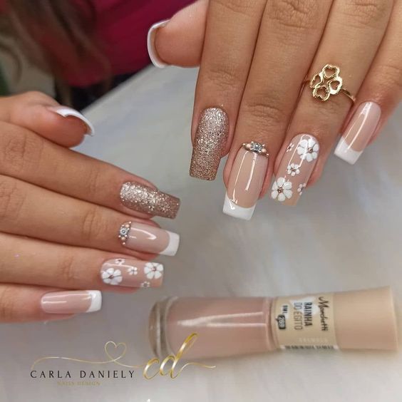 unhas decoradas com detalhe em francesinha e adesivos de flores