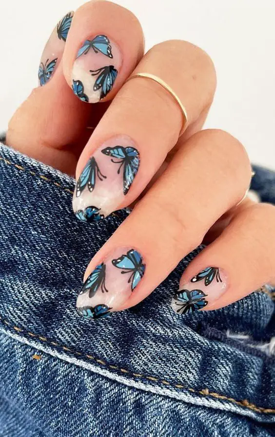 unhas de gel com adesivos de borboletas azuis