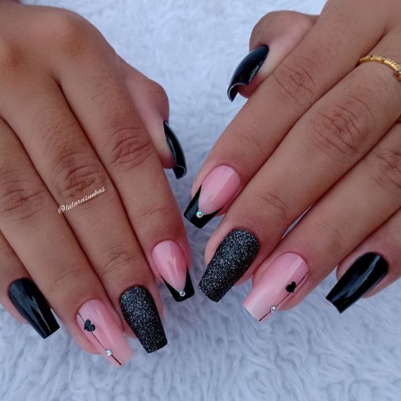 unhas simples e decoradas com esmalte preto e adesivos