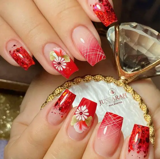 unhas decoradas com adesivos vermelhos de flores