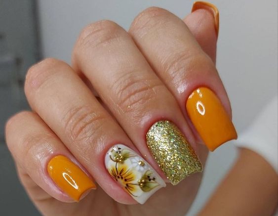 unhas na cor laranja com brilhos dourados e adesivos lindos