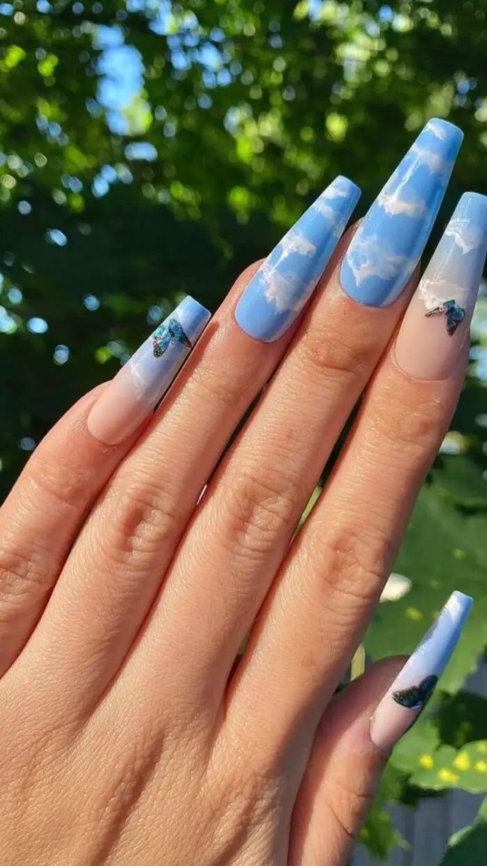 exemplo de unhas longas azuis com nuvens