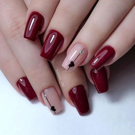 Exemplo de unhas minimalistas vermelhas com coração preto