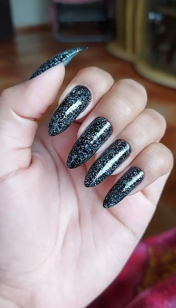 Design preto com glitter prata nas unhas 