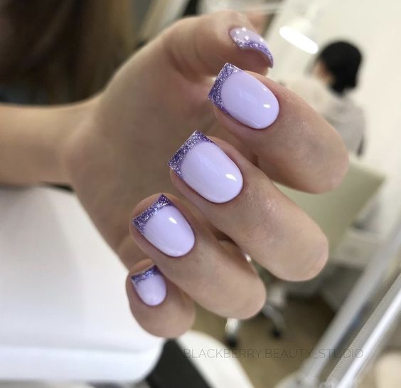 Delicado modelo de unhas lilás com glitter nas pontas roxo