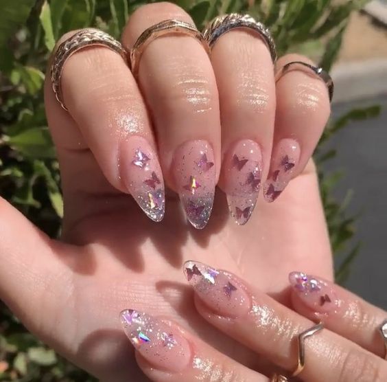 Foto de jelly nails transparente com glitter e borboletas