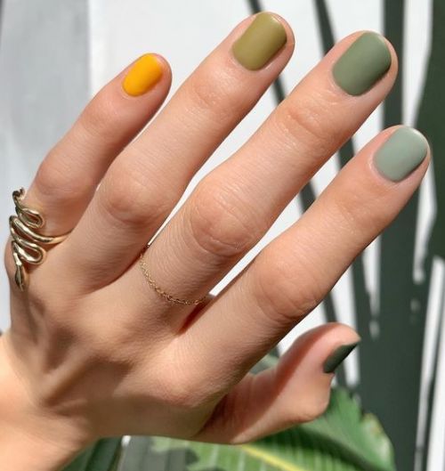 Unhas verdes com uma amarela