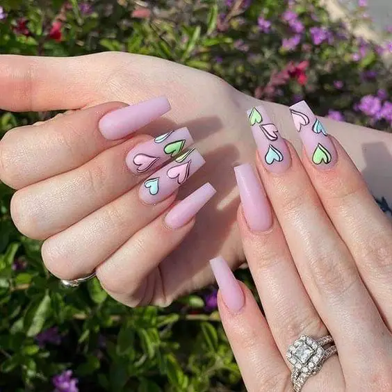 Unhas compridas rosas com corações coloridos