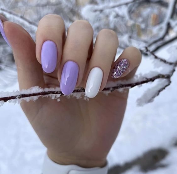 Modelo de unhas lilás com branco e glitter na neve