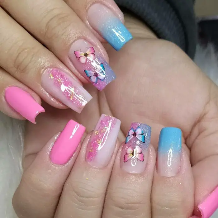 Decoração de unhas rosa e azul com glitter e borboletas