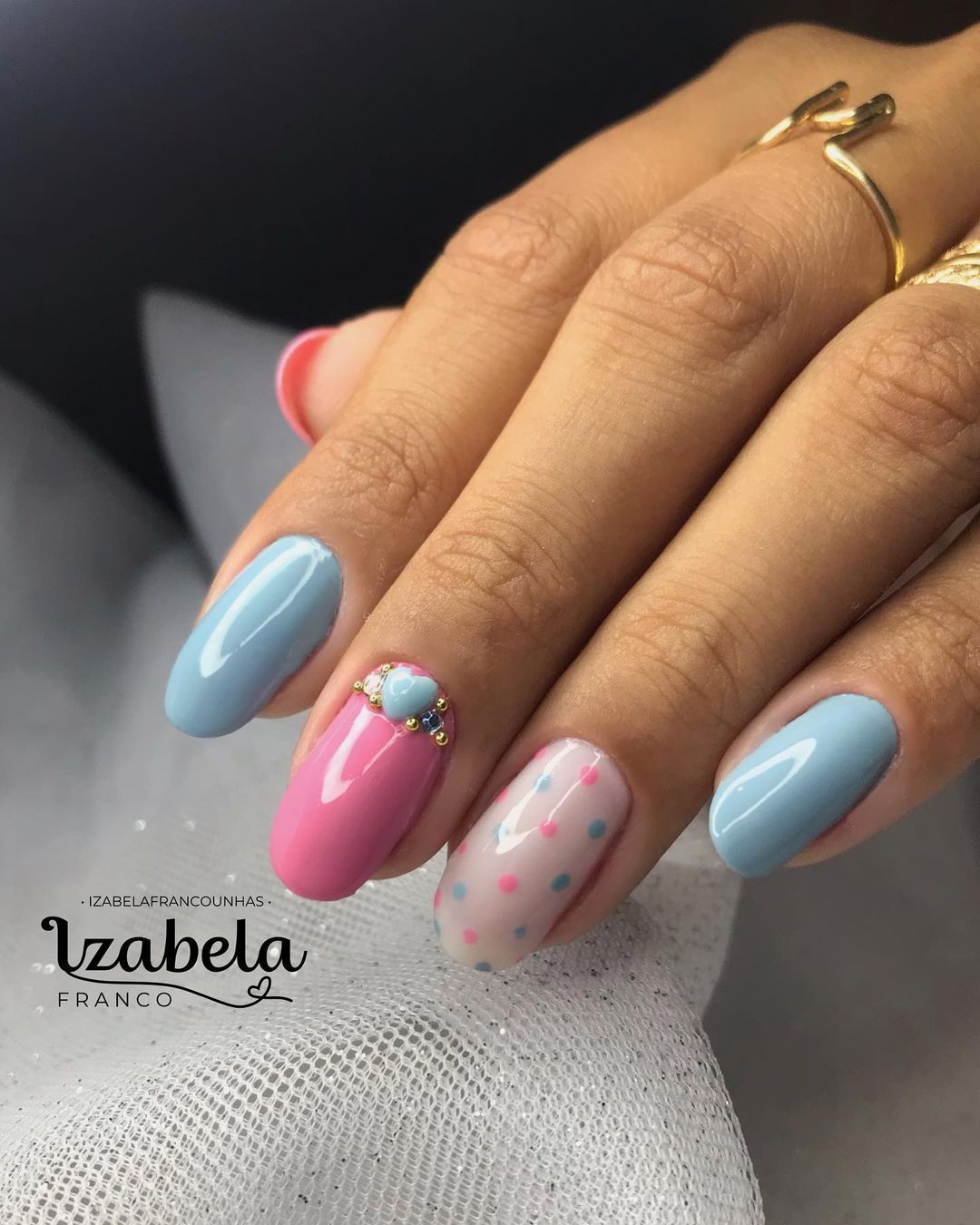 Linda esmaltação de unhas rosa e azul com joia de coração, e bolinhas