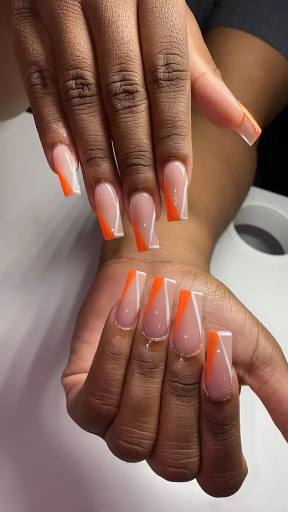 Modelo de decoração laranja e branco nas unhas