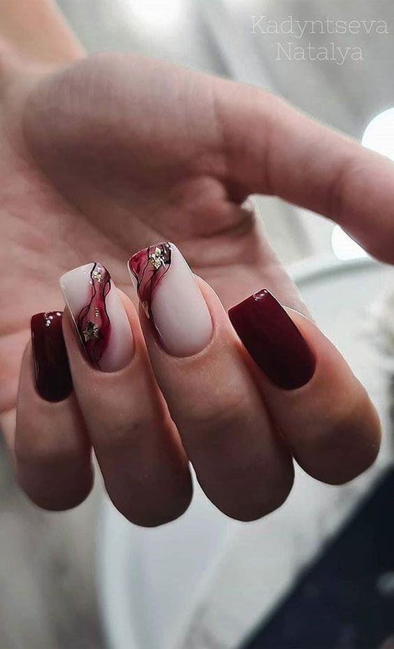 Imagem de unhas vermelho bordo com branco e detalhes marmorizados