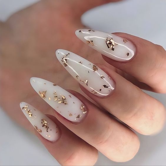 Lindas unhas brancas decoradas com folhas de ouro