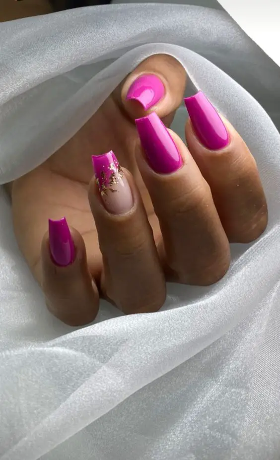 Modelo de unhas compridas rosa com folhas de ouro