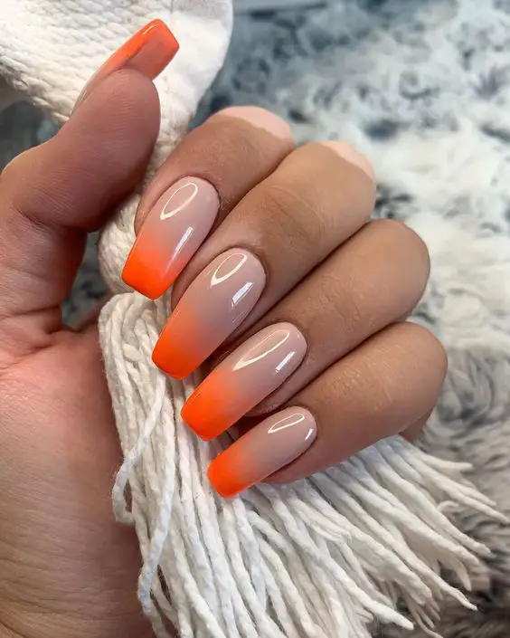 Decoração de unhas ombre nude com laranja neon