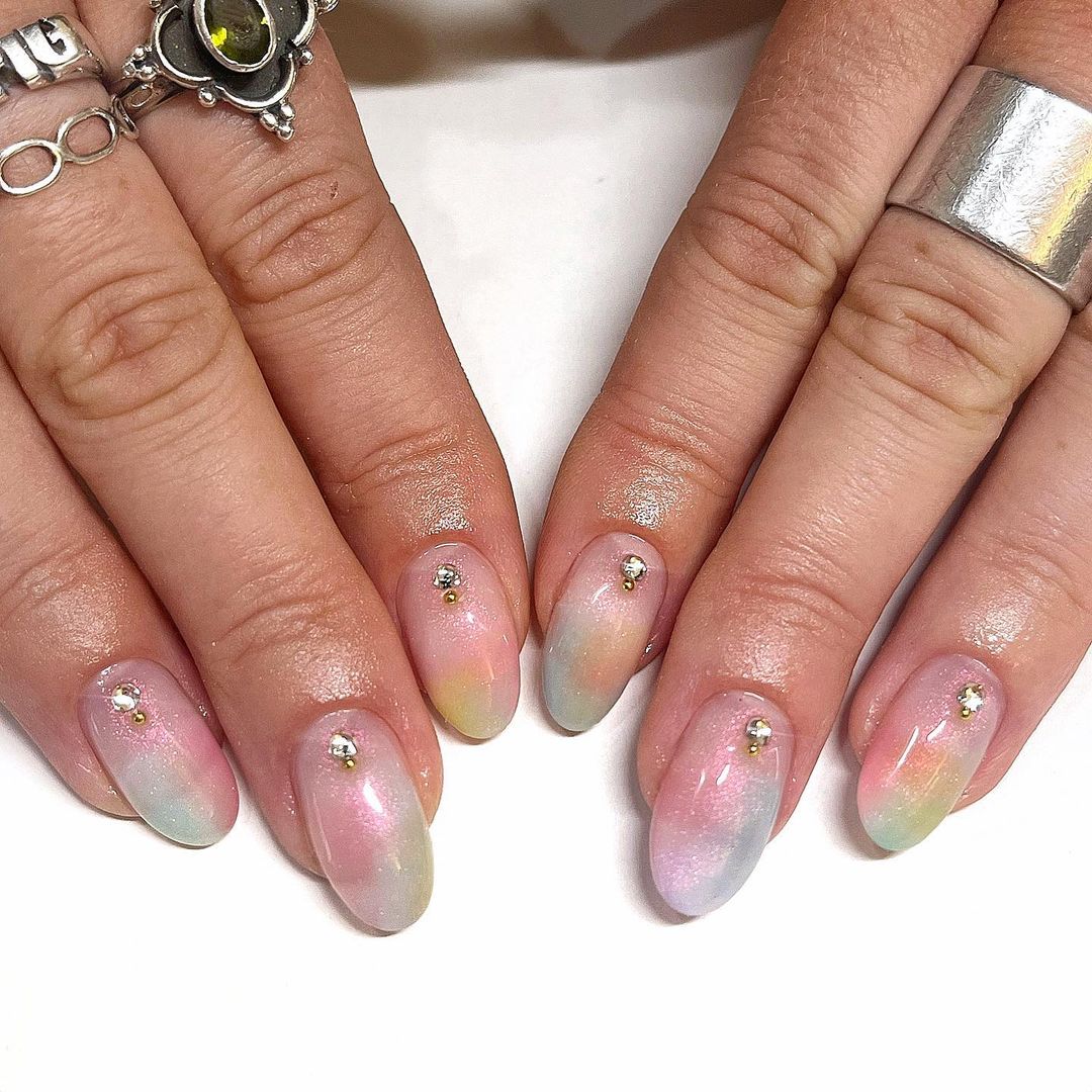 Modelo de unhas amendoadas curtas com decoração colorida e strass