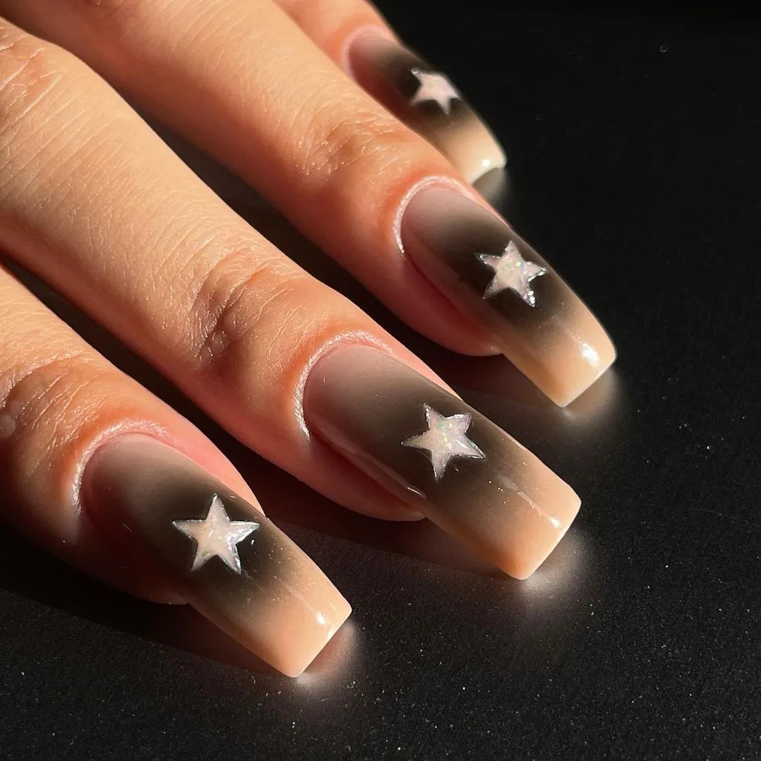 Ideia de aura nails nude com preto e com estrela no meio