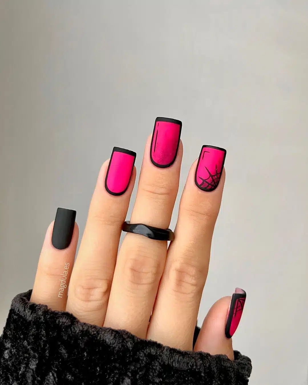 Comic nails cor de rosa com preto, com uma unha desenhada uma teia de aranha