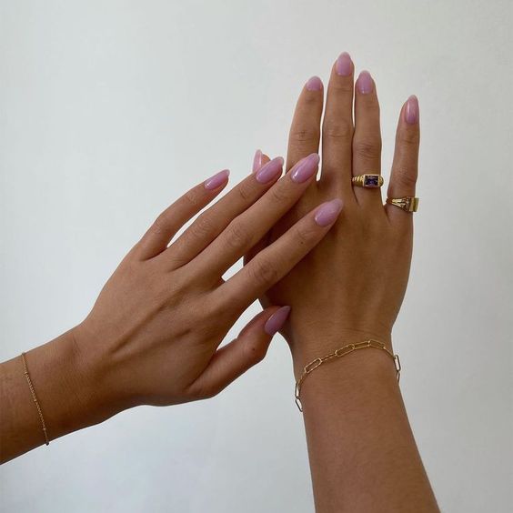 Mãos lindas com as unhas feitas com esmaltação rosinha transparente