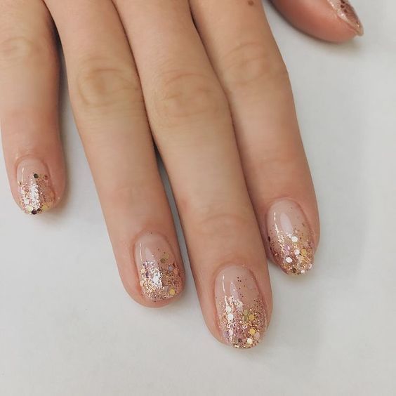 Unhas decoradas com glitter dourado na ponta